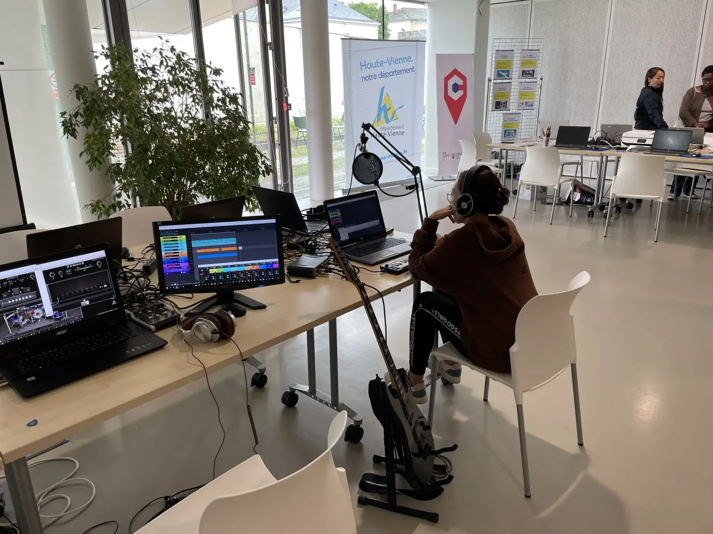 Atelier numérique dans un espace équipé avec ordinateurs et matériel audio