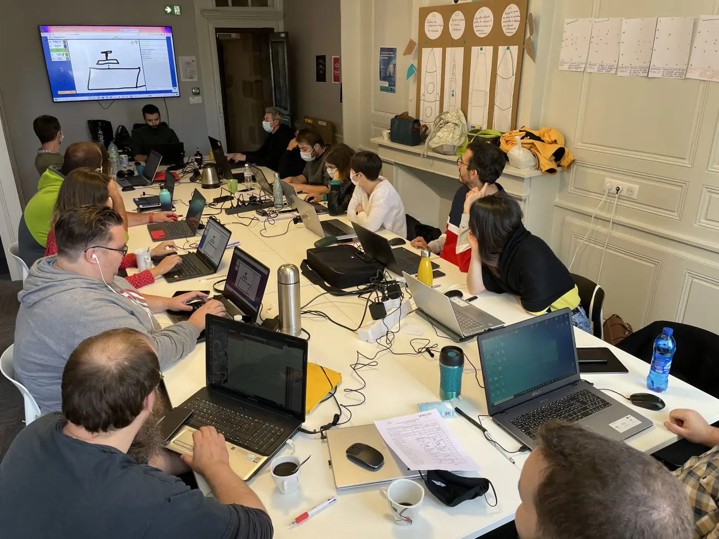 Salle de formation équipée avec participants et ordinateurs
